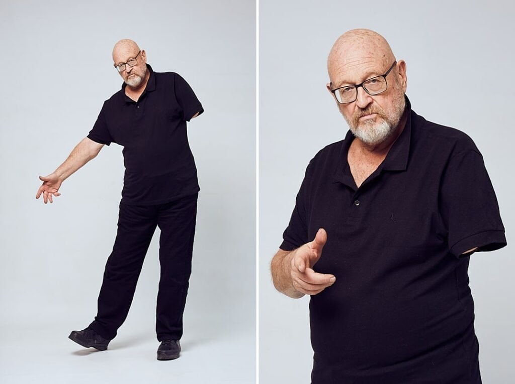 Personal branding photography of a man in his 60's with a bald head and glasses dressed in all black. Shot in studio in Cape Town, South Africa