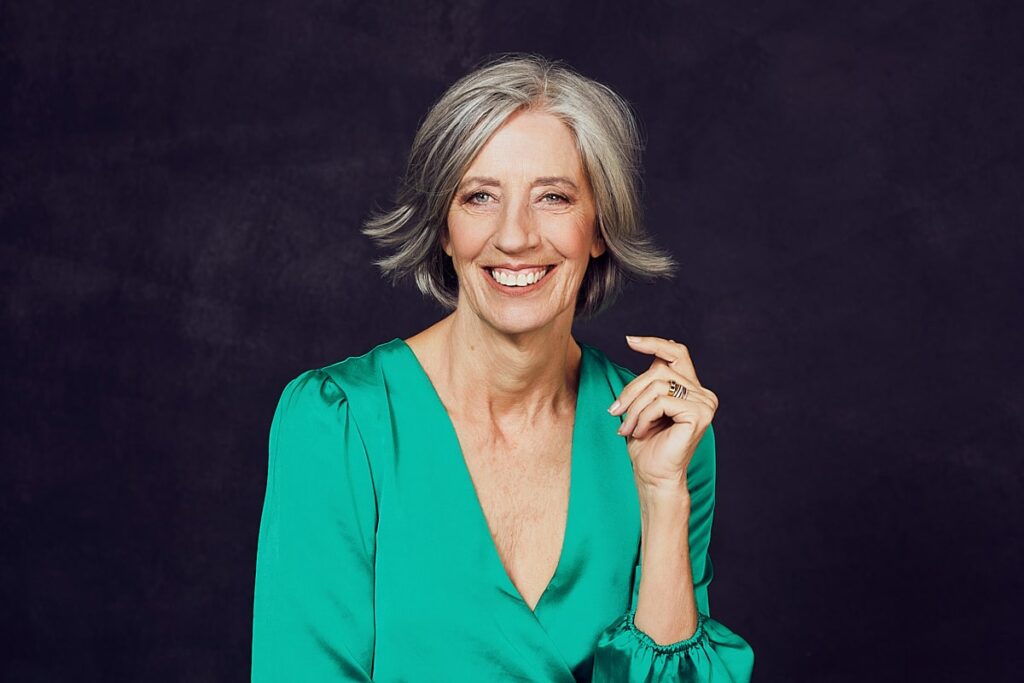 Personal branding photography of a woman in her 60's with grey hair dressed in a green dress in studio in Cape Town, South Africa